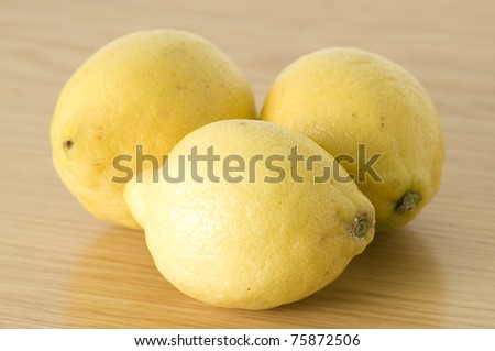 closeup of a group of yellow lemons isolated on a wooden background