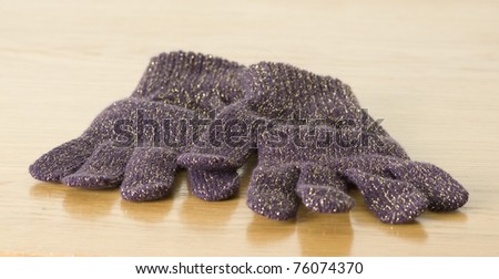 purple winter gloves isolated on a wooden background