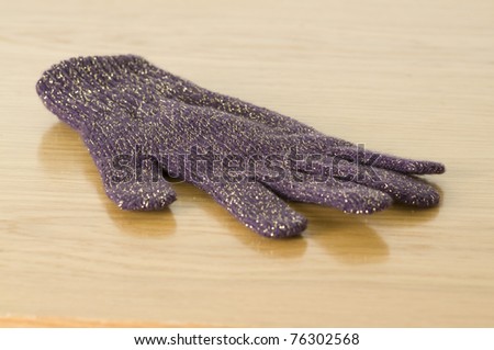 purple winter glove isolated on a wooden background
