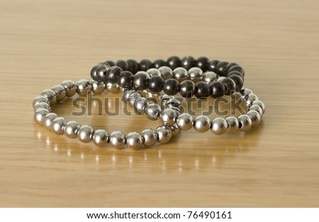 silver bracelets isolated on a wooden background