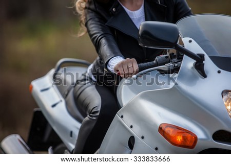 woman in black sitting on motorcycle