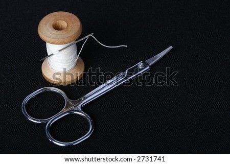 needl in spool of thread with scissors