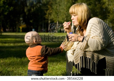 mother make soap bubbles with child