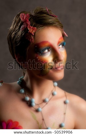 girl with butterfly make-up on face look right