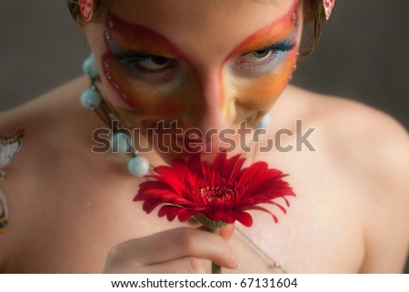 girl with butterfly make-up on face and flower