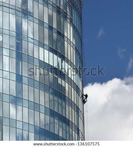 Worker cleans windows of the skyscraper building
