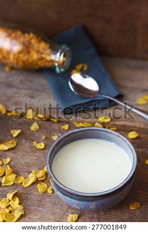 Bowl of Milk with Cereal on Wooden as Background in Vertical View.