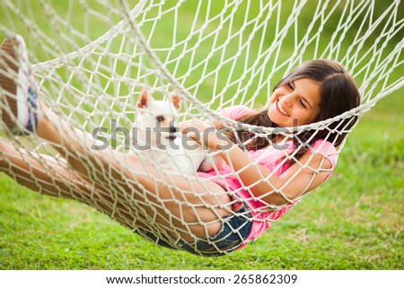 Happy girl with her dog resting in hammock