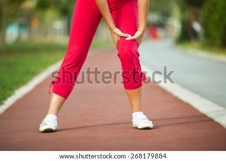 Woman having pain in leg while jogging