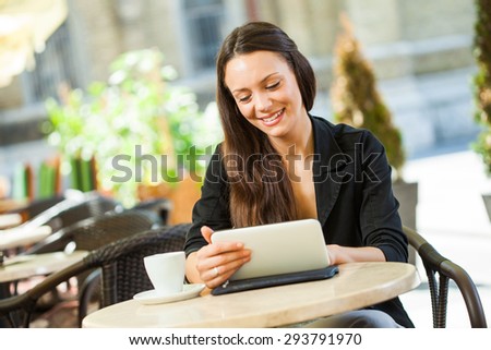 Young woman surfing the net on digital tablet in a cafe