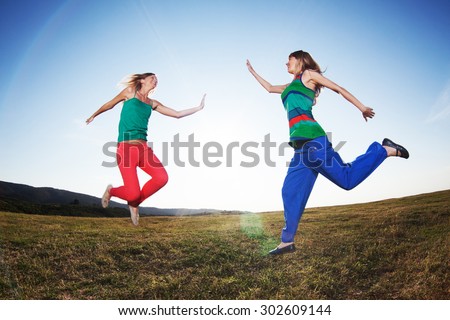Happy girls jumping in nature, image shot with fish-eye lens