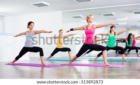 Four girls practicing yoga, Yoga - Virabhadrasana/Warrior pose
