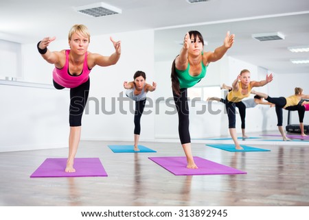 Four girls practicing yoga, Yoga-Virabhadrasana III /Warrior Pose III