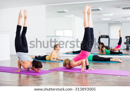 Four girls practicing yoga, Yoga-Vrschikasana / Scorpion pose