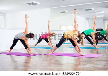 Four girls practicing yoga, Trikonasana Bikram/Bikram triangle right