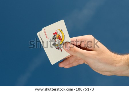 Hand holding two joker cards,blue sky in background