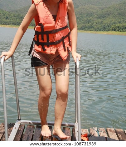 asia women with orange life jacket, natural lake background