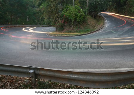 sharp curve road with car light line
