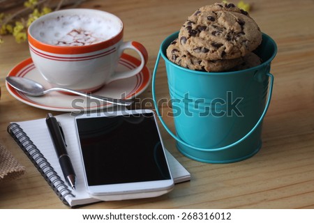 notebook pen and coffee cup with cake and cookie