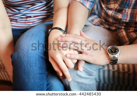 man and women holding hand together, family concept, warm feeling between man and woman sit together on sofa and hand hold for power up heart energy, serious and worry feeling