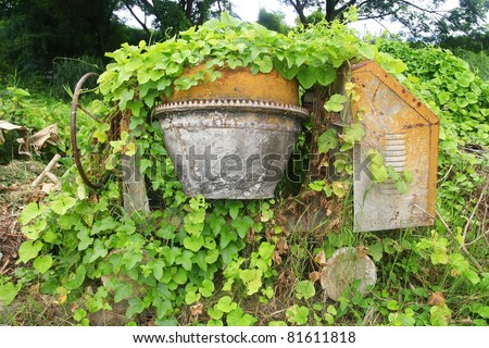 The old cement mixer machine over by leaves