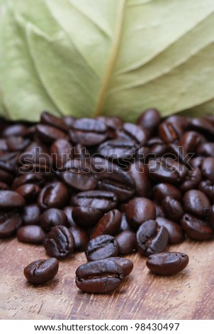 coffee beans onwooden table and dry leave package