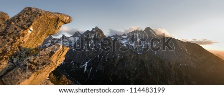 View of the mountains from the path with a mark of tourist trail on the rock. Sunset in the Tatra Mountains.