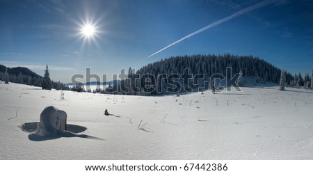 Winter panorama of mountain meadow with the sun. Below the peak of the Great Choc.