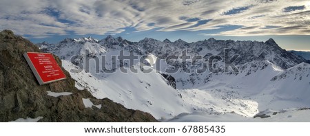 Panorama of the of the winter Tatra Mountains with a red plate. Five Lakes Valley from Zawrat.
