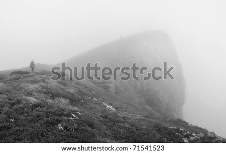Two hiking men in the fog. Cloudy Slovakian Tatra Mountains. B&W