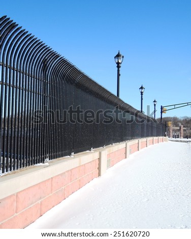 Street and a black steel fence in winter