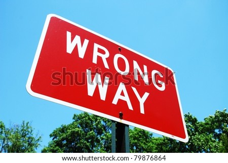 wrong way road sign on a blue sky background