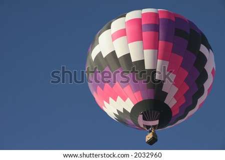 Colorful hot air balloon against clear blue sky with plenty of space for text