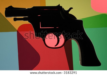 Image of a gun against a background of multi-colored tiles