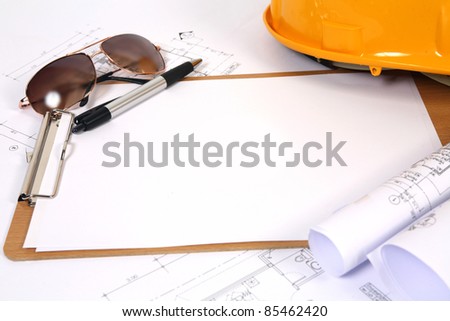 yellow hard hat and blueprints background