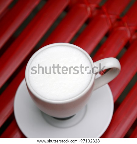 close up hot milk cup on red table