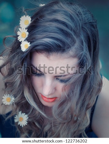 Portrait of a beautiful 20 year old woman with long hair and flowers in her hair.
