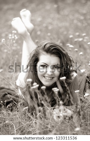 20 year old woman lying down on the grass, black and white image.