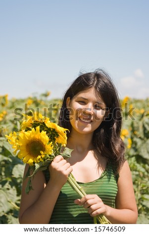 Young woman having fun in the sunflower field.