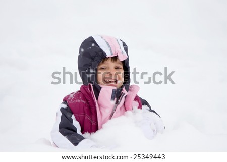 Toddler girl having fun in the snow.