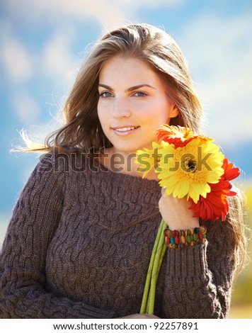 Beautiful young woman with flowers spending a beautiful day outdoors.
