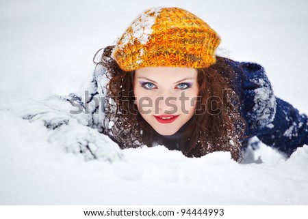 stock photo Beautiful 20 year old young woman laying in the snow in winter 