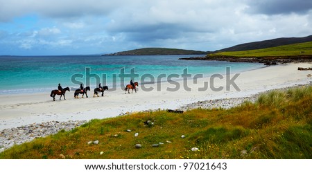 Four riders and horses on the Sellerna beach, Cleggan, in summertime, Ireland.