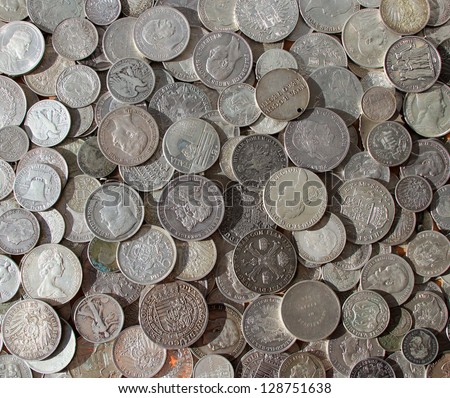 Ancient silver coins in a background photo.