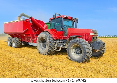 Overloading Grain Harvester Into The Grain Tank Of The Tractor Trailer