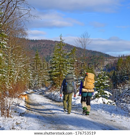 Tourists on winter mountain road.