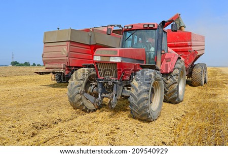 Overloading grain harvester into the grain tank of the tractor trailer