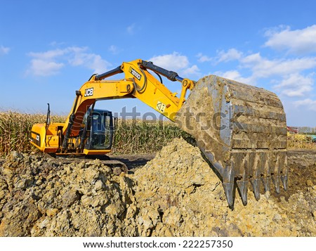 Kalush, Ukraine - October 7: Modern JCB excavator on the highway pipeline performs excavation work in the field near the town Kalush, Western Ukraine October 7, 2014