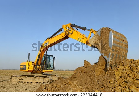 Kalush, Ukraine - October 14: Modern JCB excavator on the highway pipeline performs excavation work in the field near the town Kalush, Western Ukraine October 14, 2014