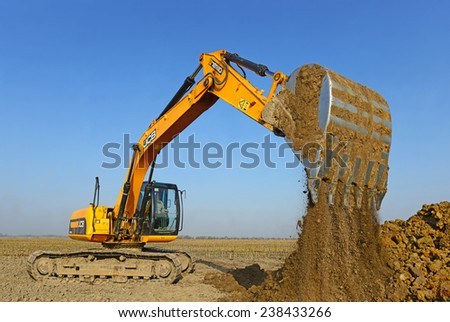 Kalush, Ukraine October 14: Modern JCB excavator on the highway pipeline performs excavation work in the field near the town Kalush, Western Ukraine October 14, 2014